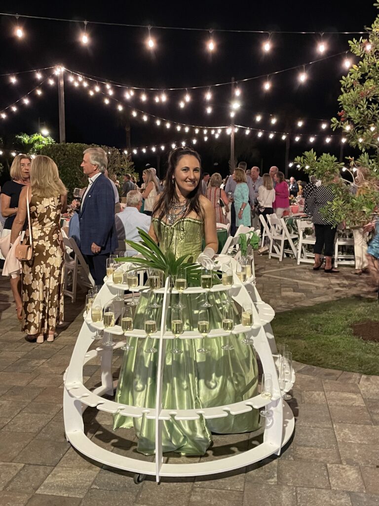 Elegant champagne strolling table entertainer serving guests at a luxury wedding reception